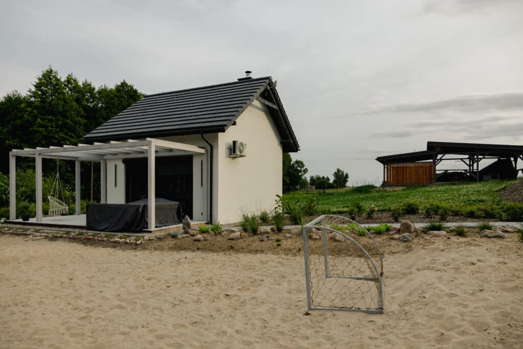 Domek Czapla w Ptasim Siedlisku – biały domek z pergolą i tarasem