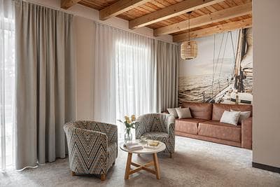 Maisonette Lux apartment at Rezydencja AMBRE, Łeba – living room with wooden ceiling, sailboat mural and armchairs