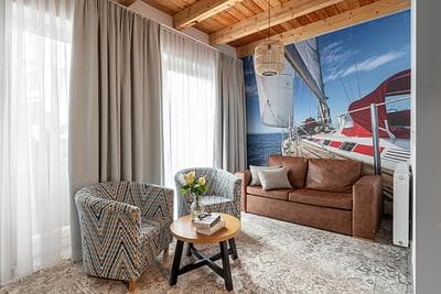Maisonette Comfort Plus apartment at Rezydencja AMBRE, Łeba – living room with sailboat mural, leather sofa and armchairs
