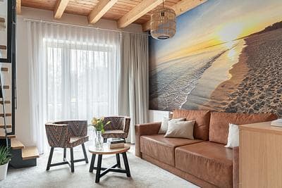 Maisonette Comfort apartment at Rezydencja AMBRE, Łeba – living room with beach mural, leather sofa and armchairs