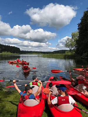 Group of paddlers in red kayaks on the lake